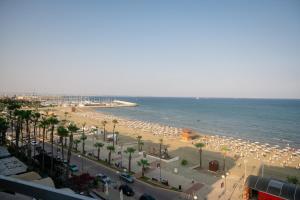 - une plage avec de nombreux parasols et l'océan dans l'établissement Quattro Beachfront Sea View Ap 53, à Larnaka