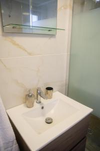 a bathroom with a white sink and a mirror at Quattro Beachfront Sea View Ap 53 in Larnaka