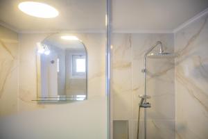 a bathroom with a shower and a mirror at Quattro Beachfront Sea View Ap 53 in Larnaka