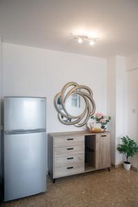 a kitchen with a refrigerator and a mirror on the wall at Quattro Beachfront Sea View Ap 53 in Larnaka