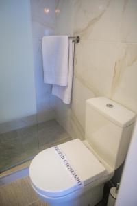 a bathroom with a white toilet and a shower at Quattro Beachfront Sea View Ap 53 in Larnaka