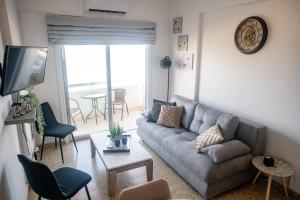 a living room with a couch and a tv at Quattro Beachfront Sea View Ap 53 in Larnaka