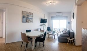 - un salon avec une table et un canapé dans l'établissement Quattro Beachfront Sea View Ap 53, à Larnaka