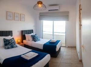 a bedroom with two beds and a window at Quattro Beachfront Sea View Ap 53 in Larnaka