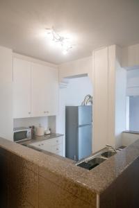 a kitchen with a counter top and a refrigerator at Quattro Beachfront Sea View Ap 53 in Larnaka