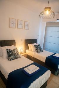 a bedroom with two beds and a light fixture at Quattro Beachfront Sea View Ap 53 in Larnaka