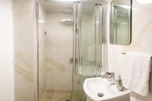 a bathroom with a shower and a sink at Quattro Beachfront Sea View Ap 53 in Larnaka +37 photos