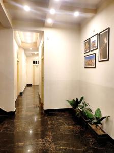 a hallway with white walls and potted plants at Bhagyashree Guest House in Varanasi
