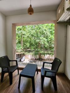 a room with two chairs and a table and a window at Dia BNB in Assagao