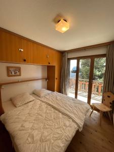 Un dormitorio con una cama grande y una ventana en Greppons COSY & MOUNTAIN apartments by Alpvision Résidences, en Veysonnaz