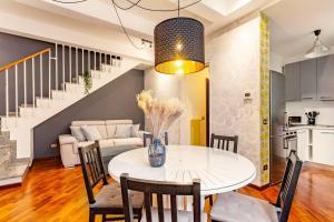 a dining room and living room with a white table and chairs at Design Villa with parking Navigli Milan sleeps5 in Milan