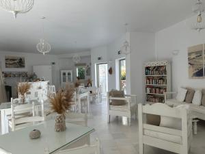 Artemis Hotel في أنتيباروس تاون: غرفة معيشة بيضاء مع كراسي وطاولات بيضاء