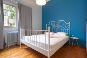 a bedroom with a white bed with a blue wall at Athens armonia 2 bedrooms 4 pers. apartment by MPS in Athens