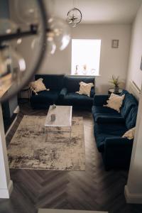 濱海聖安妮斯的住宿－The Windmill, Lytham St Annes，客厅配有蓝色的沙发和咖啡桌