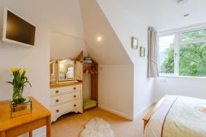 a bedroom with a bed and a dresser and a window at Urquhart Bay B&B in Drumnadrochit