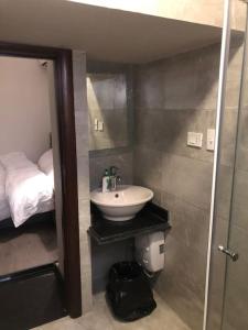a bathroom with a sink and a toilet and a bed at Lovely studio in the heart of heliopolis, cairo in Cairo
