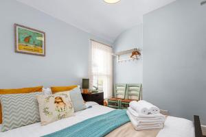 um quarto com uma cama com almofadas em Beautiful Townhouse, great location - Pet Friendly em Cardiff