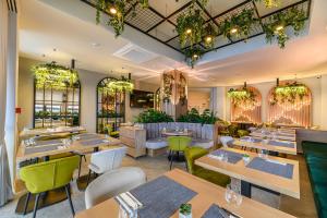 ein Restaurant mit Holztischen und grünen Stühlen in der Unterkunft Hotel DUKAT in Gura Humorului