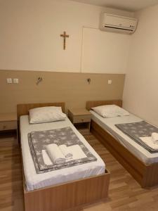 默主歌耶的住宿－Rooms Ante，墙上有十字架的房间,设有两张床
