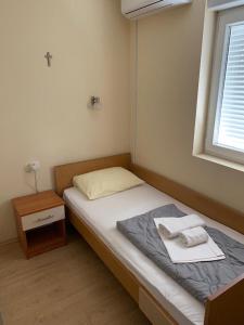 uma pequena cama num quarto com uma janela em Rooms Ante em Međugorje