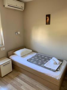 um pequeno quarto com uma cama e uma ventoinha em Rooms Ante em Međugorje