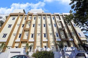 a tall tan building with a lot of windows at Super Capital O De Alphabet Kakinada in Kākināda