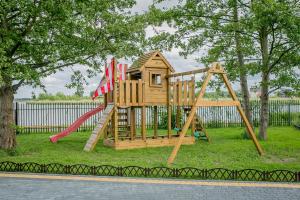 a wooden playground with a slide and a swing at Marina Mielno z widokiem na jezioro in Mielno