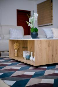 a wooden coffee table with vases and flowers on it at Irofo City Apartments in Accra