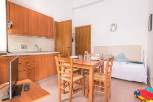 a kitchen and dining room with a table and chairs at ISA-Appartament standard 4 beds, air conditioning and private outdoor area in Village with 6 swimming-pools in Piombino