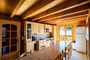 a kitchen with a table and chairs and a refrigerator at Chalet Muverant - Chatel Reservation in Châtel