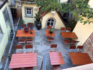 a group of wooden tables and chairs on a patio at Vinopresso GmbH - Café Römer in Prichsenstadt