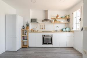 a kitchen with white cabinets and a sink at Ático Jamaica in Salobreña