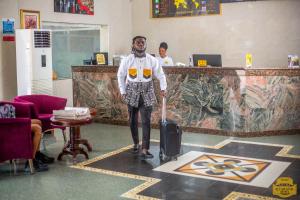 a man is pulling a suitcase in a room at MJ Grand Hotel in East Legon +80 photos
