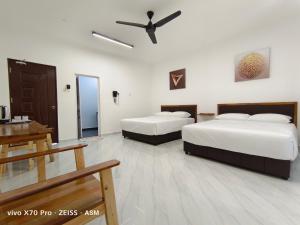 a hotel room with two beds and a ceiling fan at ASM Roomstay-4-2 Queen Beds in Kuala Terengganu
