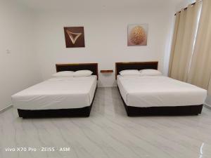 dwa łóżka w pokoju z dwoma w obiekcie ASM Roomstay-4-2 Queen Beds w mieście Kuala Terengganu