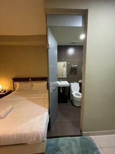 a bedroom with a bed and a bathroom with a toilet at Al Amin Muslim Friendly Hotel in Kuala Lumpur
