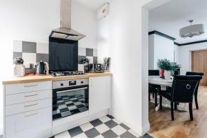 a kitchen with a stove top oven next to a table at Chic 1 Bed Flat Zone 2 Hampstead Swiss Cottage in London