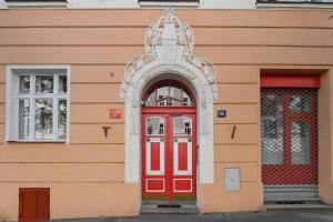 une porte rouge sur le côté du bâtiment dans l'établissement Kubelíkova 32 Residence, à Prague