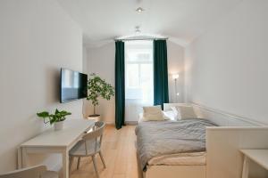 - une chambre avec un lit, une table et un bureau dans l'établissement Kubelíkova 32 Residence, à Prague