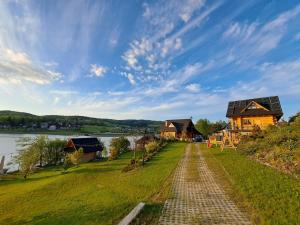 a house on the side of a river with a road at Gazdówka in Bartkowa-Posadowa