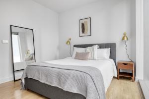 a white bedroom with a large bed and a mirror at Loop 2br w lounge gym nr Chicago Riverwalk CHI-959 in Chicago +49 photos