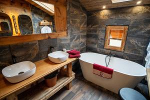 een badkamer met 2 wastafels en een bad bij Savoya Lodges in Châtel