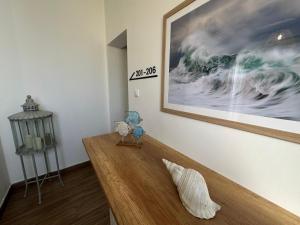 a living room with a wooden table with a picture on the wall at The Beach House in Birżebbuġa