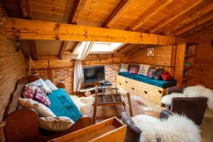 a living room with a couch and a tv in a cabin at Savoya Lodges in Châtel