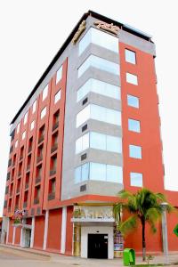 a tall orange building with a palm tree in front of it at Rio Boutique Hotel in Pucallpa