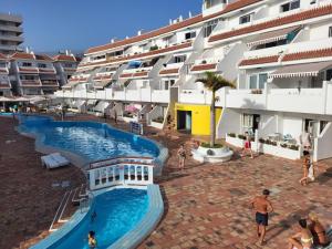 a hotel with a swimming pool in front of a building at NEWQUAY in Playa de las Americas