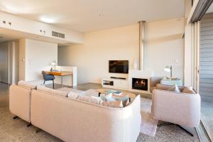 een woonkamer met 2 banken en een open haard bij Smiths Beach Resort in Yallingup