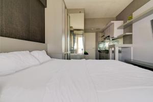 1 cama blanca grande en una habitación pequeña en OYO Life 92889 Apartement Grand Sentraland Karawang By A.t Room, en Karawang