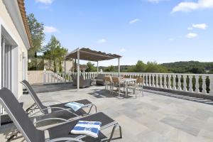 a patio with chairs and a table on a balcony at Villa KIP, private pool & jacuzzi surrounded by nature in Pinar de Campoverde