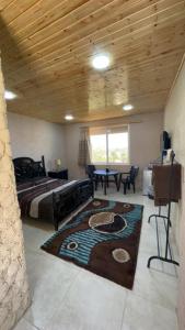 a bedroom with a bed and a rug on the floor at Green Garden Rooftop in Madaba
